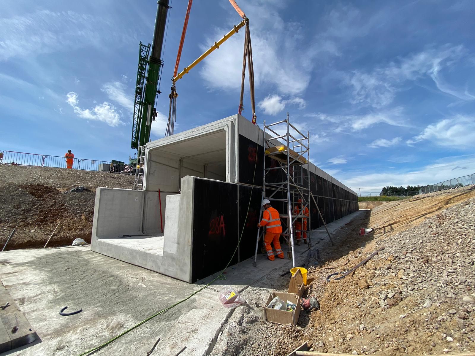 Construction workers installing a precast concrete culvert on the HS2 project, with health and safety measures in place. Paul Feely & Associates supports Paul Mulcair UK Ltd with compliance, RAMS, and site safety inspections.